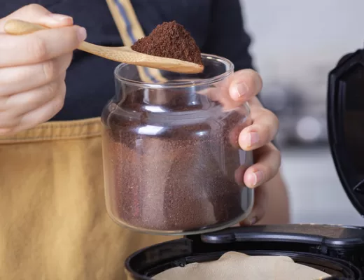 Hands measuring coffee from jar